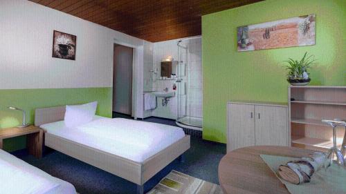 a bedroom with a white bed and a bathroom at Hotel Luitpold in Landshut