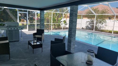a large swimming pool with a table and chairs next to a table at CAPE CORAL CANALFRONT in Cape Coral