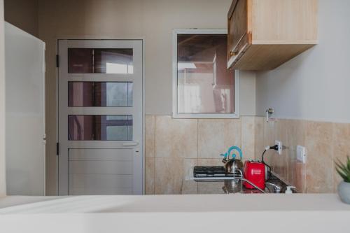 埃斯克爾的住宿－KUPAL，一个带门和红色用具的厨房