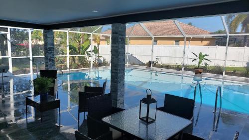 a large swimming pool with a table and chairs in a house at CAPE CORAL CANALFRONT in Cape Coral
