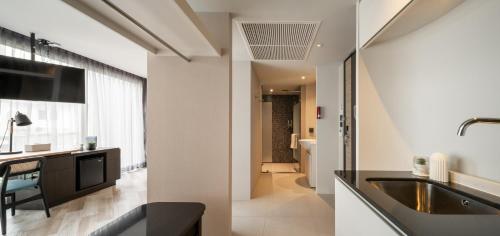 cocina con paredes blancas, lavabo y baño. en Seekers Finders Rama IV Hotel SureStay Collection by BW en Bangkok