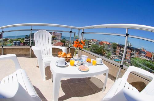 a white table and chairs on a balcony at Hotel Fontanet in Villa Gesell