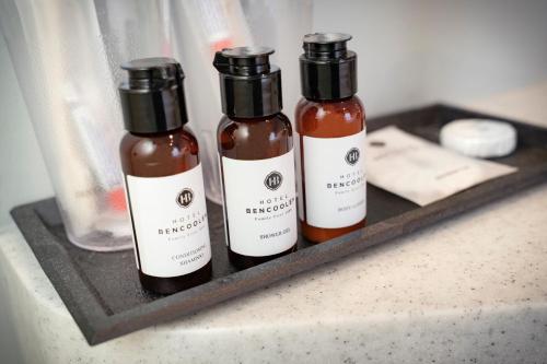 three bottles of sauce sitting on a shelf at Hotel Bencoolen at Hong Kong Street in Singapore
