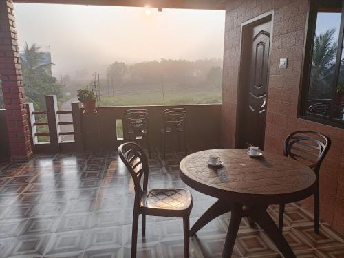 um pátio com uma mesa e cadeiras e uma janela em Maanyatha Home Stay em Manipal
