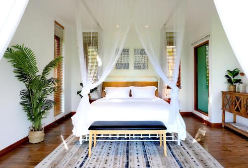 a bedroom with a white bed with a canopy at Rice Villa Chiang Mai in Ban Wang Mun