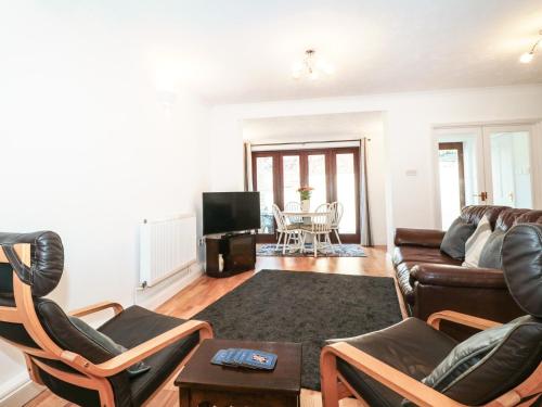 a living room with a couch and chairs at Quarry Cottage in Cheddar