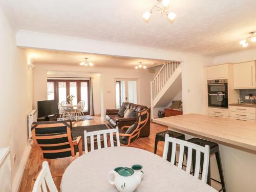 a kitchen and living room with a table and chairs at Quarry Cottage in Cheddar