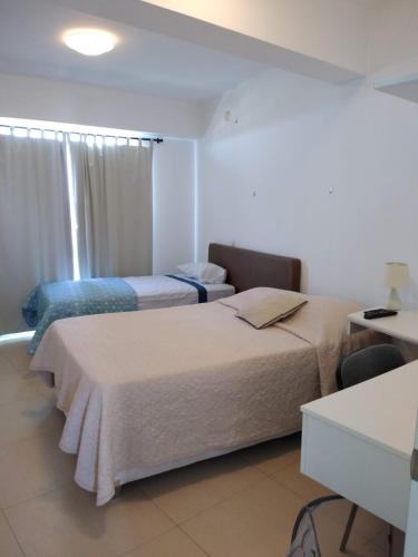 una camera d'albergo con due letti e una finestra di Acogedor departamento WiFi a Piura