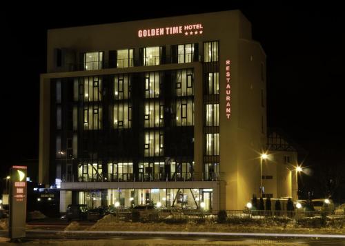 a building with a sign on it at night at Golden Time Hotel in Braşov