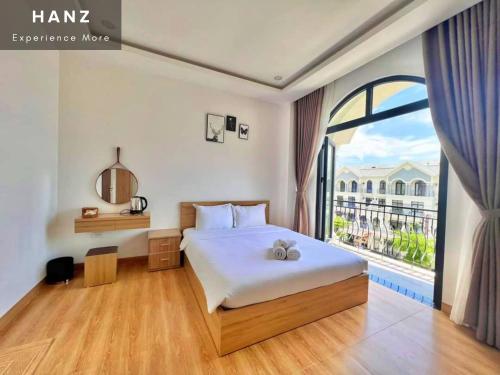a bedroom with a bed and a large window at HANZ Teddy Sunset Grand World in Phu Quoc