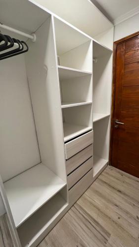 a closet with white shelves and a wooden door at Rengo Central Market in Rengo