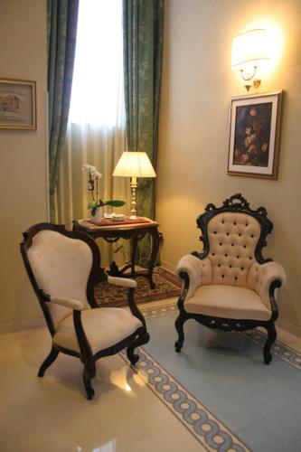 a living room with two chairs and a table at Domus Mariae Benessere in Siracusa