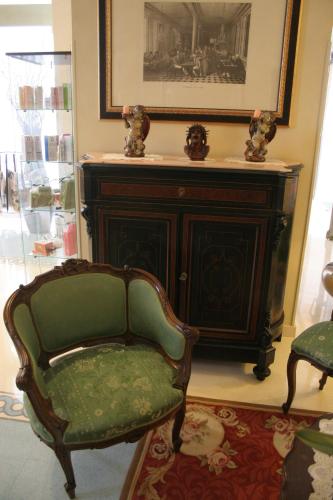 a living room with a chair and a cabinet at Domus Mariae Benessere in Siracusa