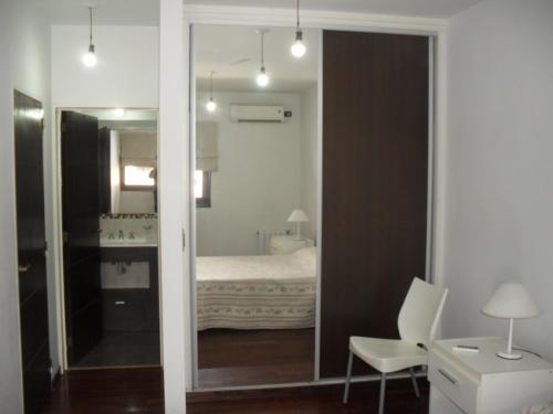 1 dormitorio con espejo y 1 cama en una habitación en Village Tower, en Villa Carlos Paz