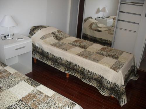 Un dormitorio con dos camas y un espejo. en Village Tower, en Villa Carlos Paz