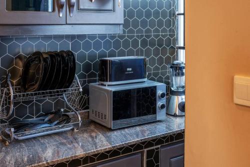 a kitchen counter with a microwave and a toaster oven at Mi Casa Su Casa - Kyanja in Kampala