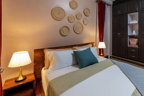 a bedroom with a large bed with two lamps at Mi Casa Su Casa - Kyanja in Kampala