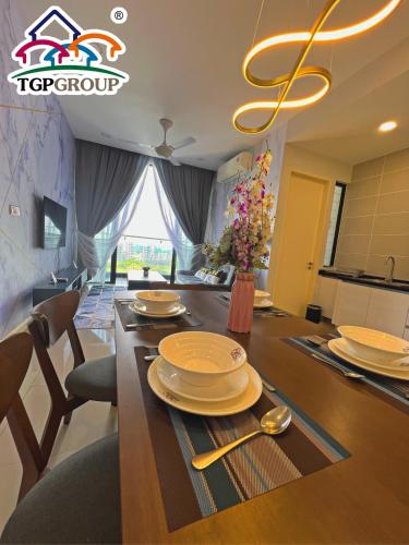 a dining room with a table with plates and utensils at Legoland D'PRISTINE Apartment By TGP in Nusajaya