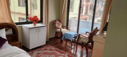 a bedroom with a bed and a table and chairs at Kathmandu Airport View Hotel And Lodge in Kathmandu
