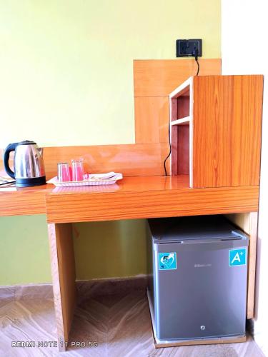 a wooden table with a microwave on top of a box under it at Hotel National Park Sauraha- Homely Stay and Peaceful Location with Jungle Safari arrangements in Sauraha