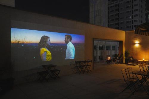 a large screen on the side of a building with tables and chairs at Good Ol' Days Hotel in Busan