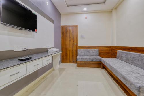 a waiting room with two chairs and a flat screen tv at Hotel Kumar Atithi Nivas in Indore