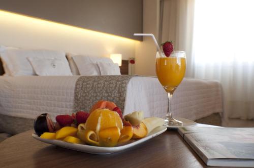 a plate of fruit and a drink on a table in a hotel room at 7 Saltos Resort in Salto del Guairá