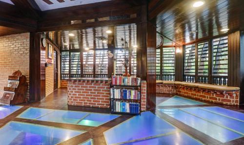 a library with a book shelf with books at Treebo Trend God'S Own Country Ayurveda Resorts in Kovalam