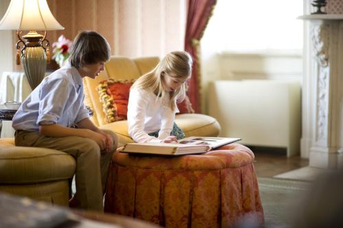two girls sitting on a couch looking at a book at John Rutledge House Inn in Charleston