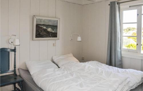 a white bed in a bedroom with a window at Beautiful Home In Flekkery With 4 Bedrooms And Wifi in Møvik