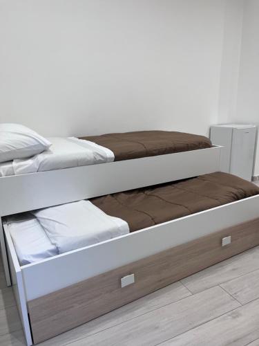 - un lit blanc avec un cadre en bois et des draps blancs dans l'établissement GLAM B&B room, à San Giuseppe Vesuviano
