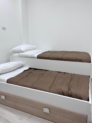 two bunk beds in a white room withlishes at GLAM B&B room in San Giuseppe Vesuviano