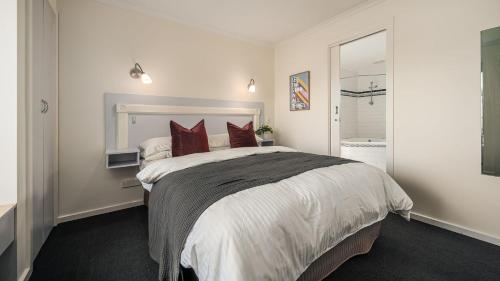 a bedroom with a large bed with red pillows at Sunshine Retreat Villa 6 in Cowes