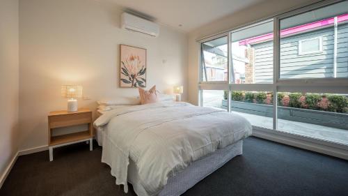 een slaapkamer met een bed en een groot raam bij Sunshine Retreat Villa 7 in Cowes