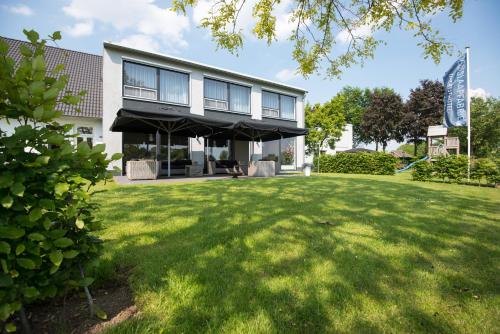 a building with a lawn in front of it at De Slaapfabriek vakantiehuis en trainingslocatie in Teuge
