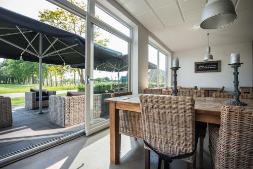 a dining room with a table and some chairs at De Slaapfabriek vakantiehuis en trainingslocatie in Teuge