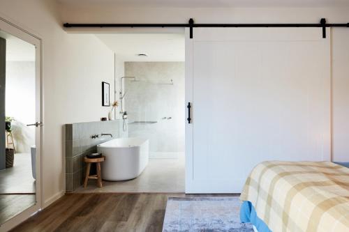 a bathroom with a tub and a shower at Lakeside Villas at Crittenden Estate in Dromana