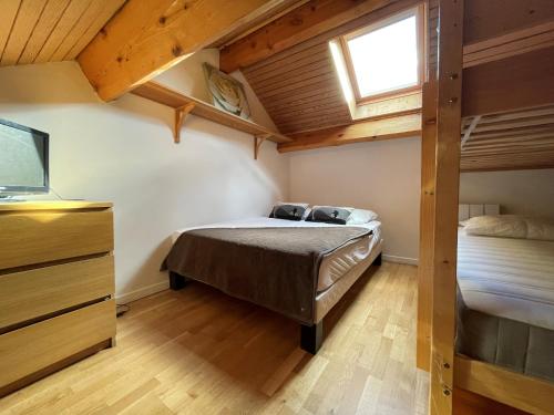 sypialnia z łóżkiem i telewizorem w pokoju w obiekcie Appartement dernier étage 3 chambres - Olympe w mieście Les Deux Alpes