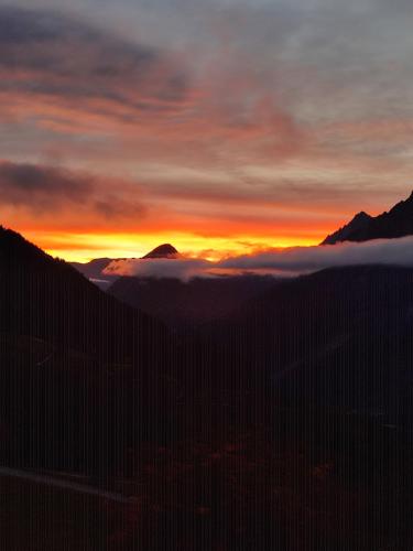 a sunset over the mountains with a layer of clouds at Appartements Obergollerhof in Assling
