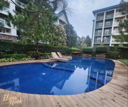 a swimming pool with chairs and a building at Casa Lucas in Tagaytay