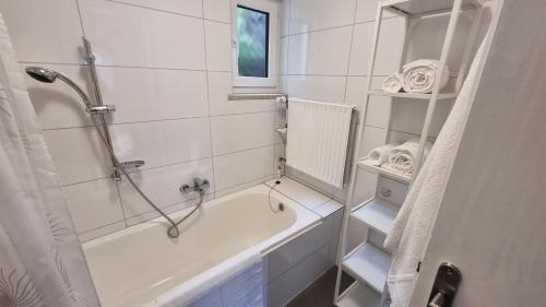 y baño blanco con bañera y ducha. en Germanus Ferienwohnung en Warmensteinach