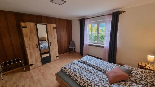 1 dormitorio con cama y ventana en Germanus Ferienwohnung en Warmensteinach