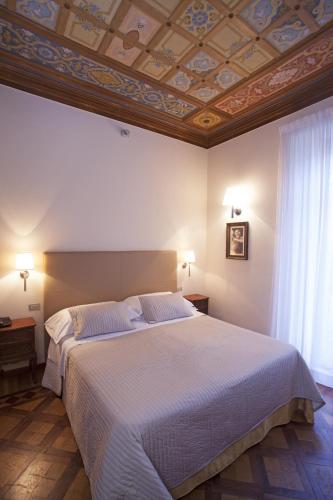 a bedroom with a large bed with a coffered ceiling at Hotel Dei Fiori Restaurant - Meeting & Spa in Alassio