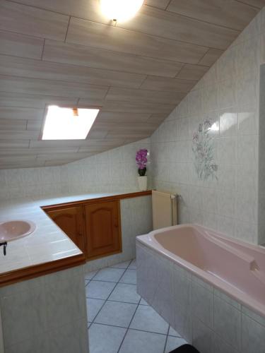 W łazience znajduje się różowa wanna i umywalka. w obiekcie Gite Le Chamoyard w mieście Chamoux-sur-Gelon