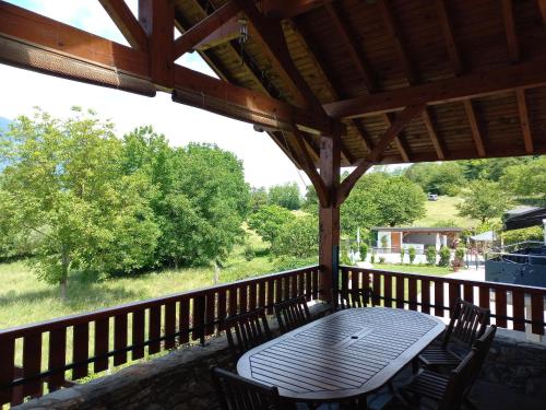 a wooden porch with a table and chairs on a deck at Gite Le Chamoyard in Chamoux-sur-Gelon