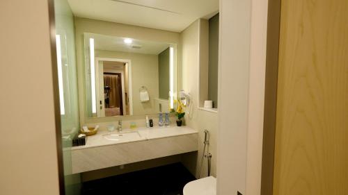 a bathroom with a sink and a large mirror at Falaj Daris Hotel in Nizwa