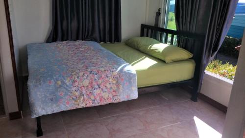 un piccolo letto in una camera con finestra di D&Dโฮม@เขาค้อ a Khao Kho