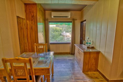 a dining room with a table and a window at Yogved Hospitality & Resort in Rishīkesh
