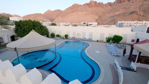a swimming pool with a painting on the side of a building at Falaj Daris Hotel in Nizwa