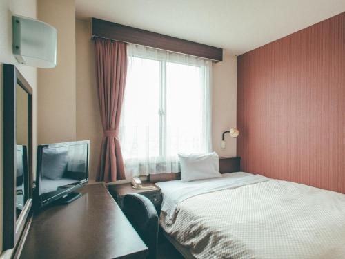 une chambre d'hôtel avec un lit et une fenêtre dans l'établissement Toyohashi Station Hotel / Vacation STAY 66965, à Toyohashi